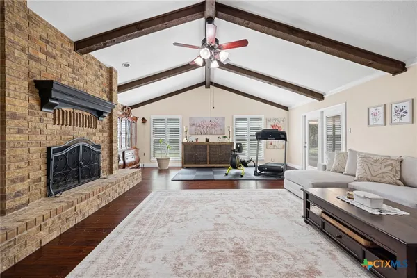 a living room with furniture a fireplace and a flat screen tv