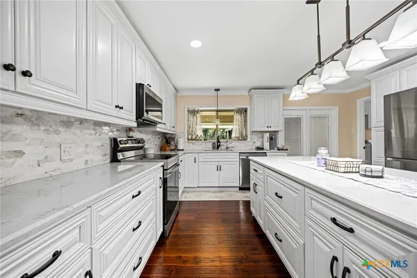 a kitchen with granite countertop a stove sink and microwave