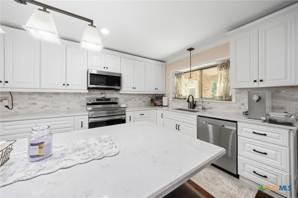 a kitchen with cabinets a sink appliances and a counter top space