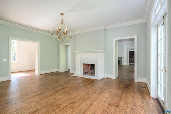 wooden floor fireplace and windows in an empty room