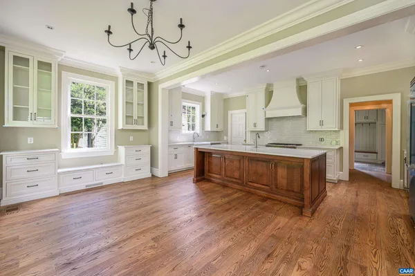 a large kitchen with stainless steel appliances granite countertop a lot of counter space and wooden floors