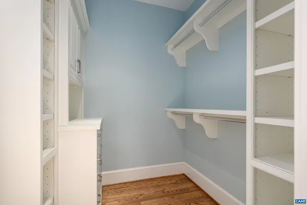 a view of a hallway with wooden floor and entryway