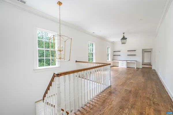 a view of empty room with wooden floor and windows