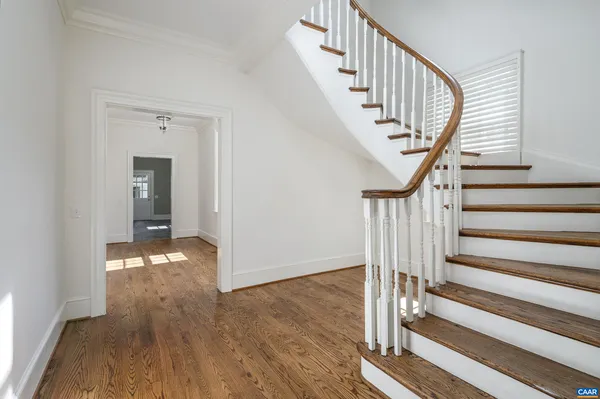 a view of staircase with wooden floor and white walls