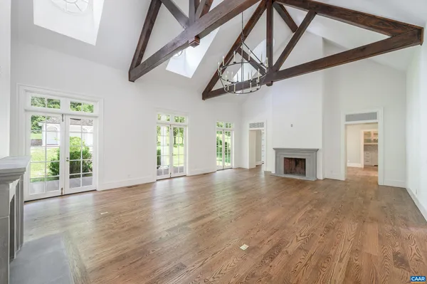 a view of empty room with fireplace and wooden floor