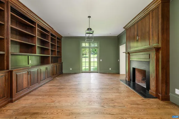 a view of an empty room with a fireplace and a window