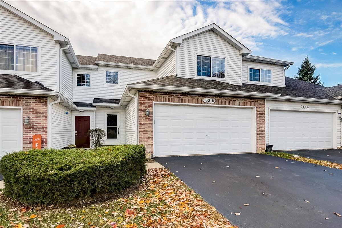 63 Rolling Oaks Road, Unit B Sugar Grove, IL 60554 - Photo 1 of 23 a front view of house with garage