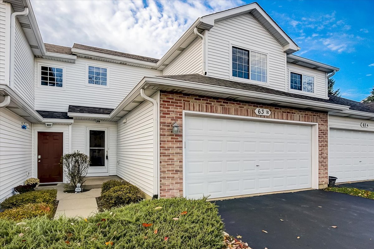 63 Rolling Oaks Road, Unit B Sugar Grove, IL 60554 - Photo 2 of 23 a front view of a house with garage