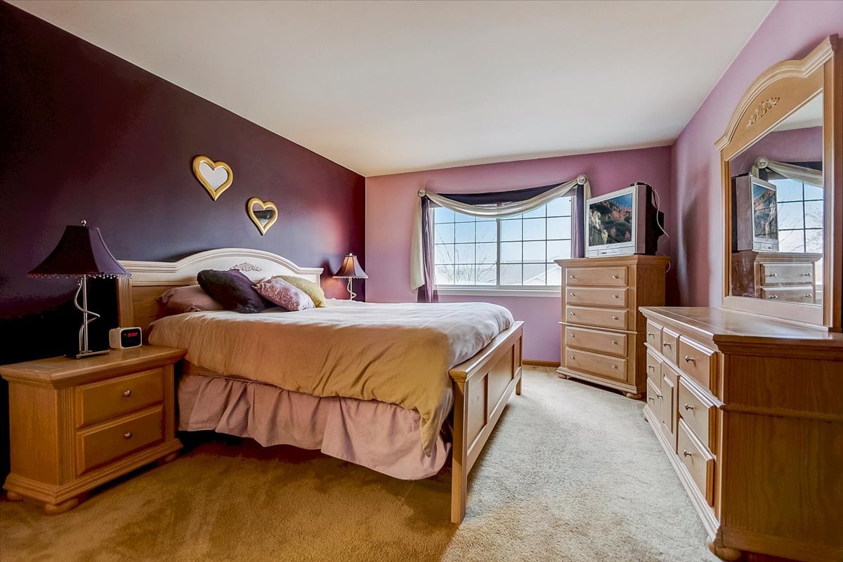 63 Rolling Oaks Road, Unit B Sugar Grove, IL 60554 - Photo 12 of 23 a bedroom with a bed and a dresser next to a window