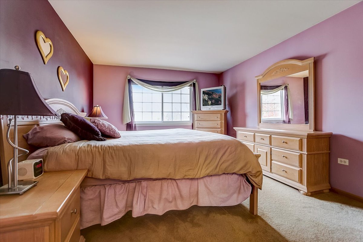 63 Rolling Oaks Road, Unit B Sugar Grove, IL 60554 - Photo 13 of 23 a bed sitting in a bedroom next to a window with dresser