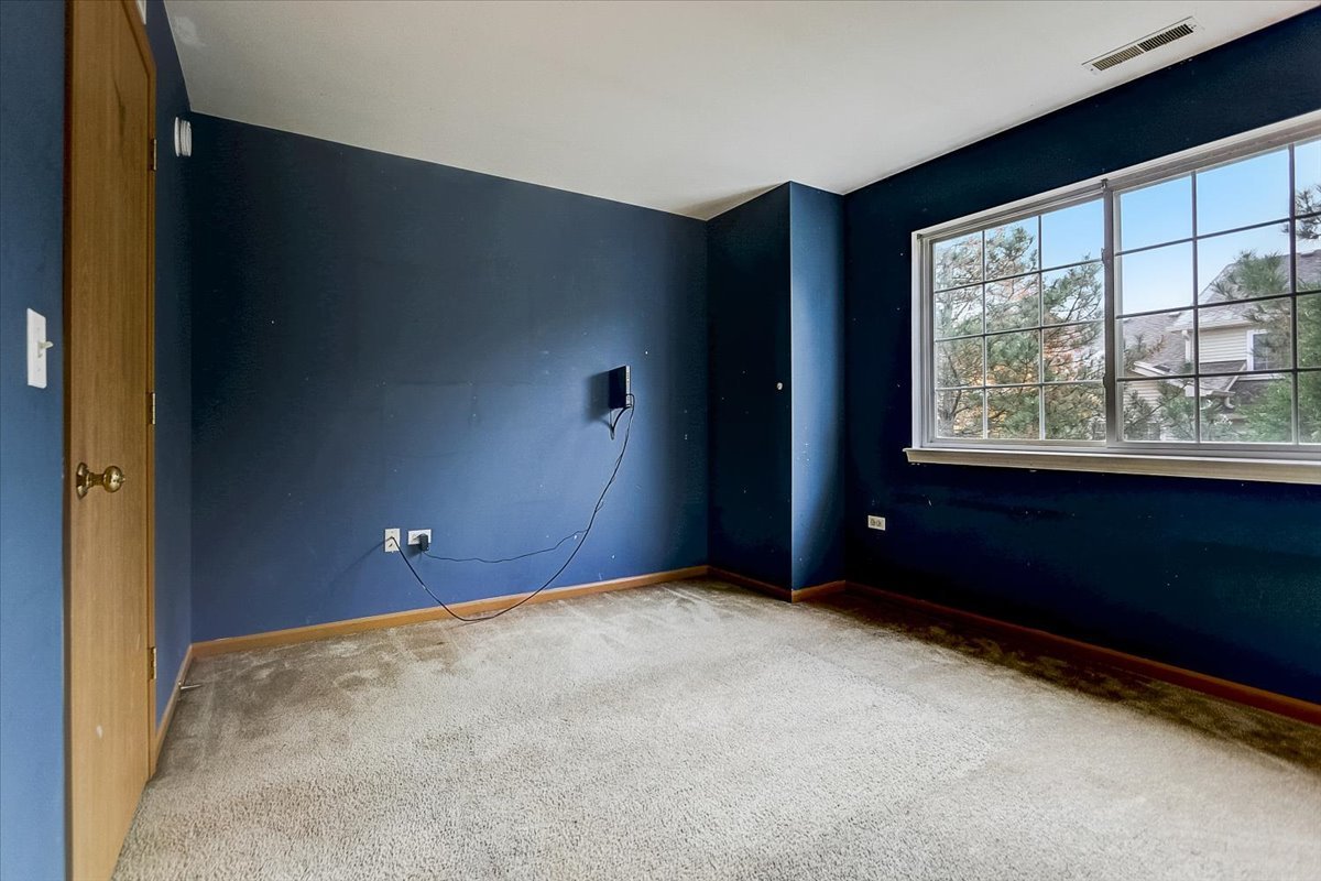 63 Rolling Oaks Road, Unit B Sugar Grove, IL 60554 - Photo 18 of 23 a view of an empty room with a window