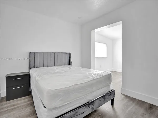 a bed sitting in a bedroom and wooden floor