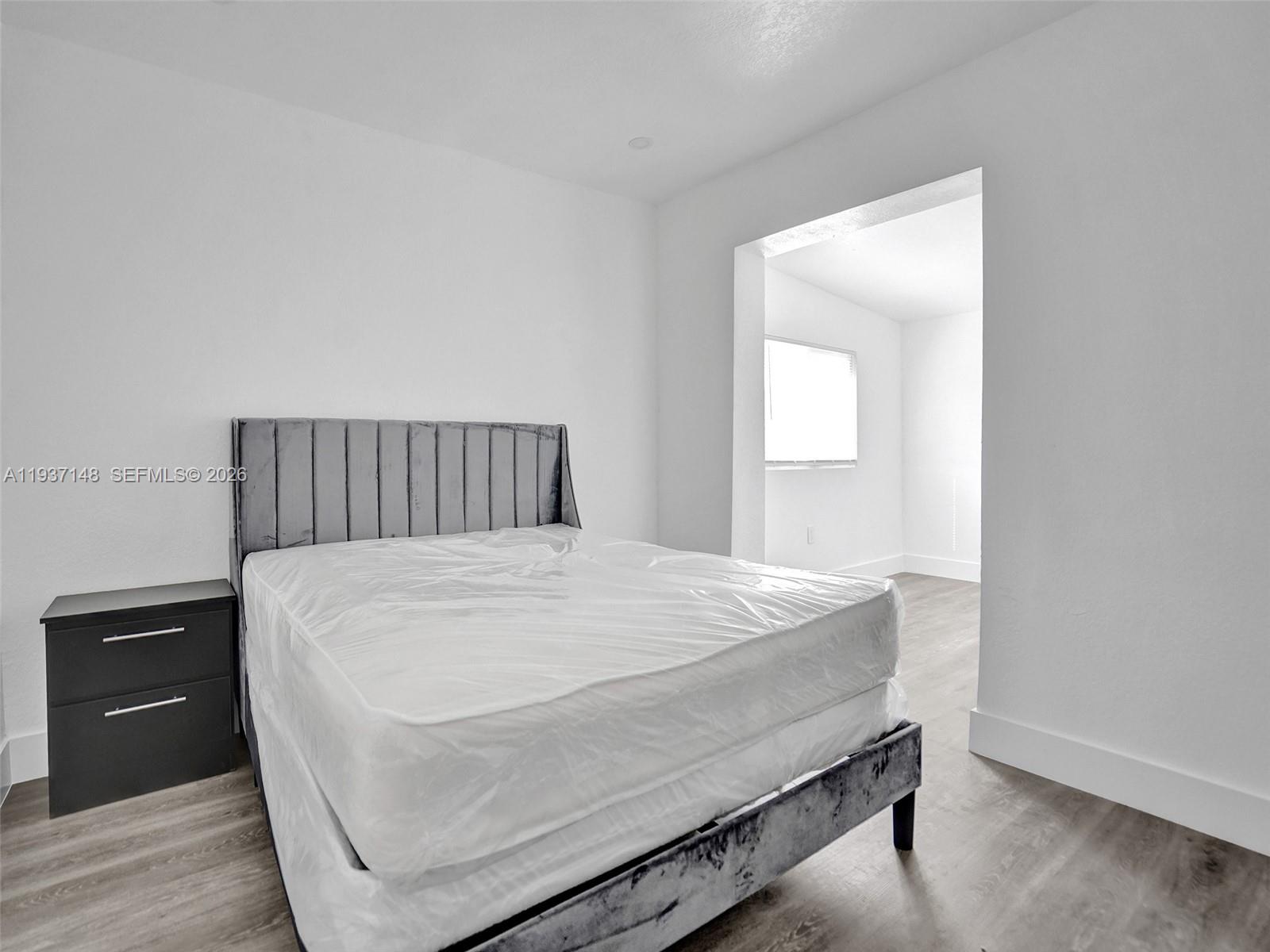 6143 Southwest 40th Street Miramar, FL 33023 - Photo 12 of 24 a bed sitting in a bedroom and wooden floor