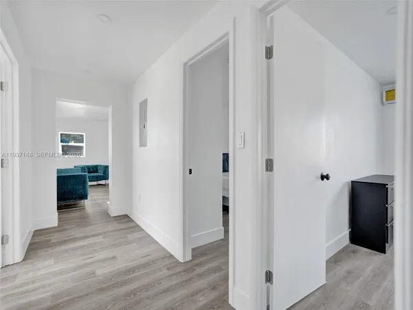 a view of a hallway with wooden floor and closet