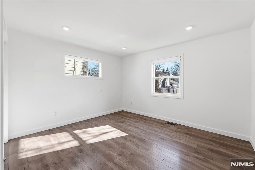 73 MacArthur Avenue Lodi, NJ 07644 - Photo 11 of 46 an empty room with wooden floor and window