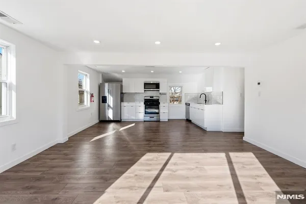 a view of an empty room with wooden floor