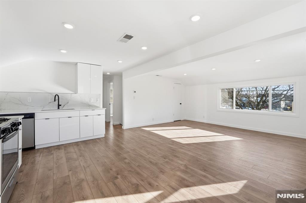 73 MacArthur Avenue Lodi, NJ 07644 - Photo 18 of 46 a view of a kitchen with a sink hardwood floor and a large window