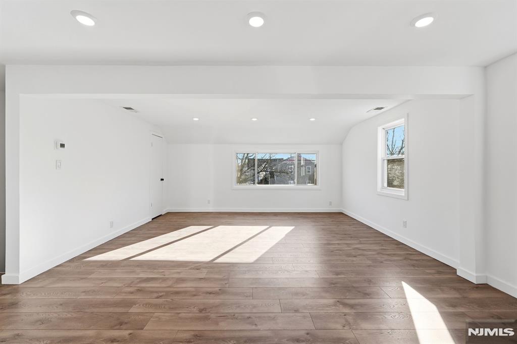 73 MacArthur Avenue Lodi, NJ 07644 - Photo 19 of 46 an empty room with wooden floor and windows