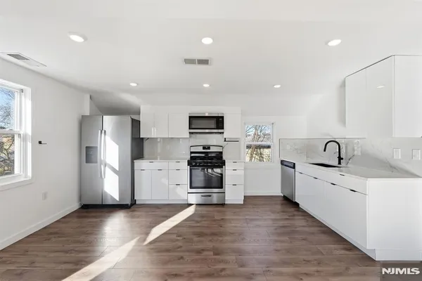a view of an empty room with wooden floor