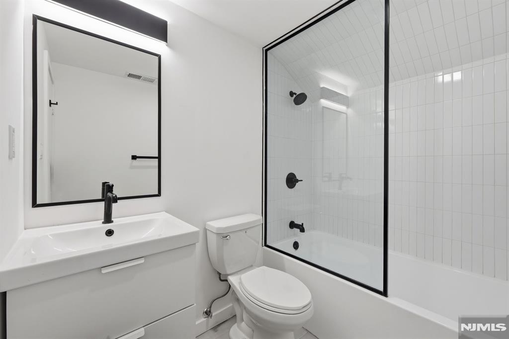 73 MacArthur Avenue Lodi, NJ 07644 - Photo 23 of 46 a bathroom with a sink a toilet and shower