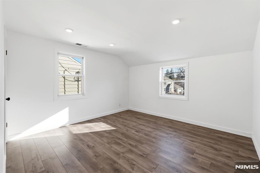 73 MacArthur Avenue Lodi, NJ 07644 - Photo 26 of 46 an empty room with wooden floor and windows
