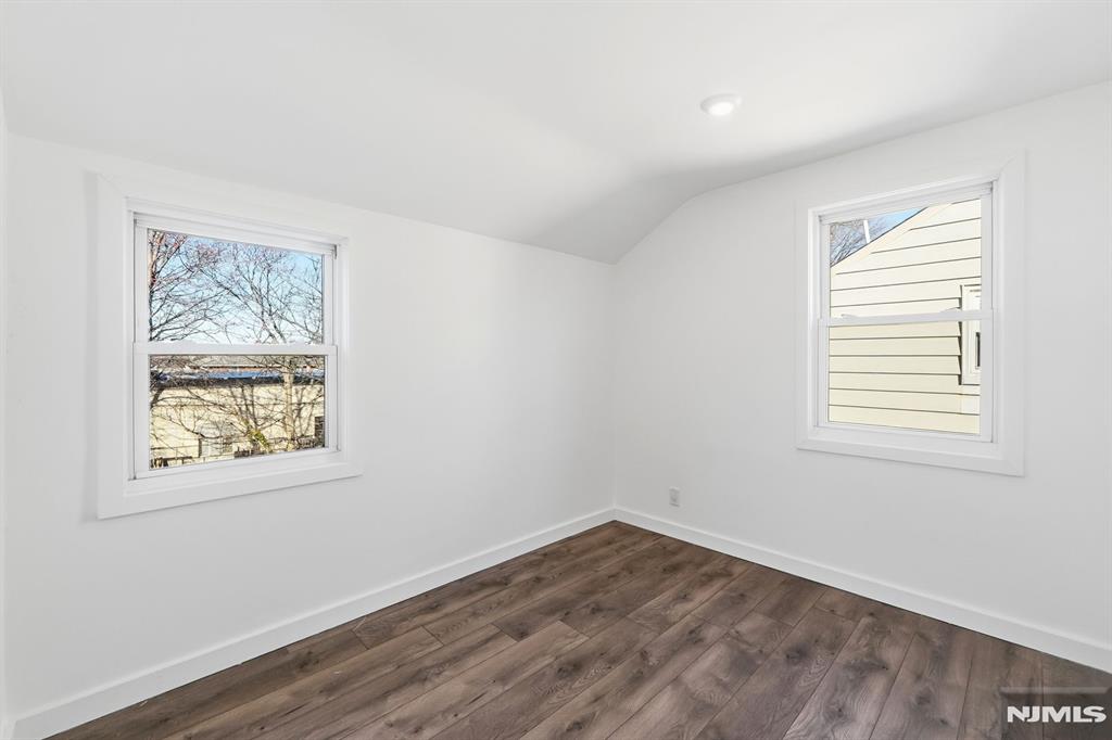 73 MacArthur Avenue Lodi, NJ 07644 - Photo 28 of 46 a view of an empty room with wooden floor and a window