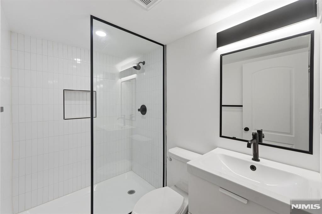 73 MacArthur Avenue Lodi, NJ 07644 - Photo 37 of 46 a bathroom with a sink and mirror