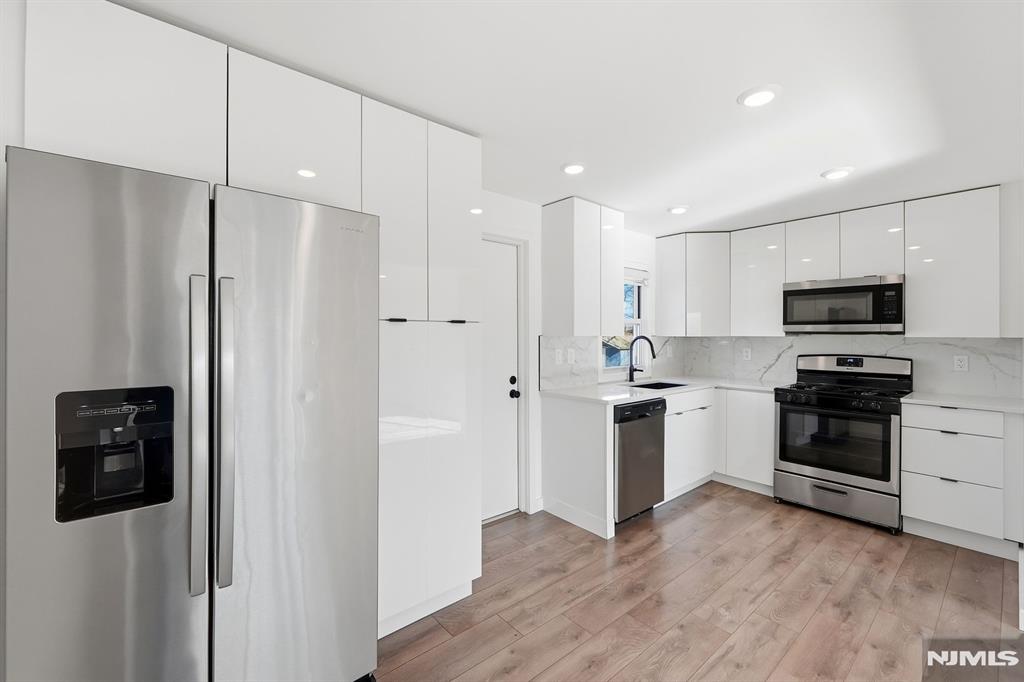73 MacArthur Avenue Lodi, NJ 07644 - Photo 5 of 46 a kitchen with stainless steel appliances a refrigerator freezer and a stove top oven