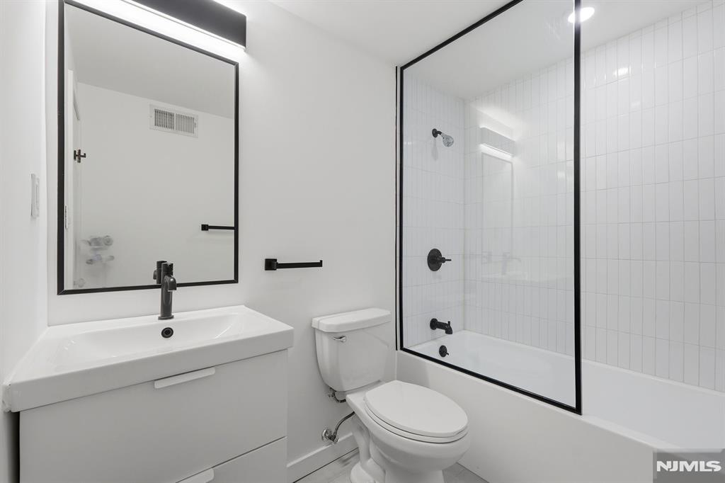 73 MacArthur Avenue Lodi, NJ 07644 - Photo 8 of 46 a bathroom with a sink a toilet and shower