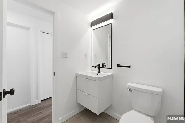 a bathroom with a toilet a sink and mirror