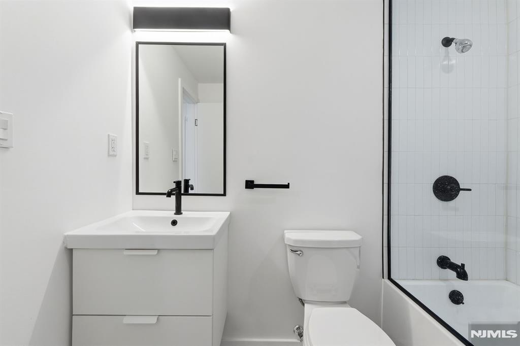 73 MacArthur Avenue Lodi, NJ 07644 - Photo 10 of 46 a bathroom with a sink a toilet and shower