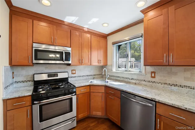 a kitchen with stainless steel appliances granite countertop a sink stove and refrigerator