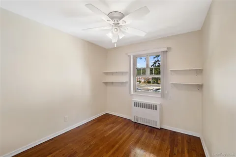 an empty room with a window and a ceiling fan