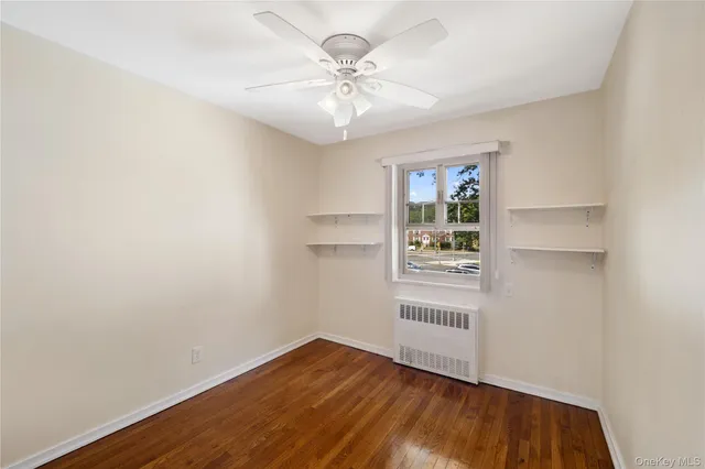 an empty room with a window and a ceiling fan