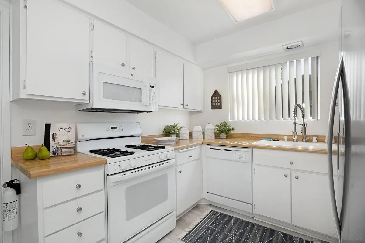 4523 Kittiwake Way Oceanside, CA 92057 - Photo 7 of 34 a kitchen with cabinets appliances a sink and a window