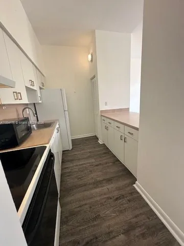 a kitchen with a sink and wooden floor