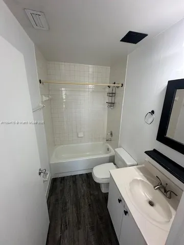 a bathroom with a granite countertop toilet sink and mirror