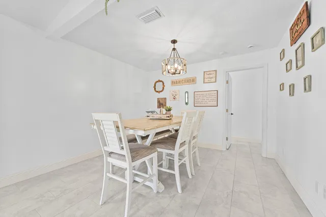 a view of a dining room with furniture and chandelier