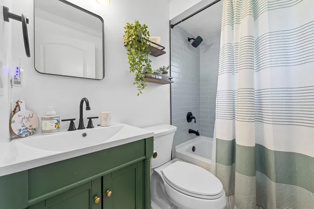 a bathroom with a sink a toilet and shower curtain