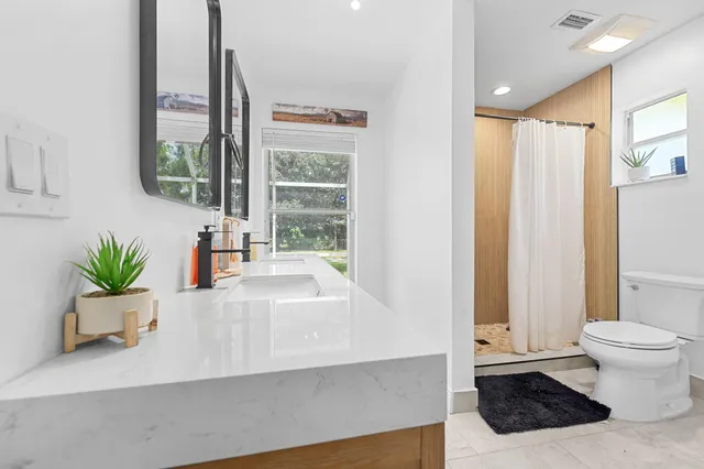 a white bath tub sitting in a bathroom next to a window