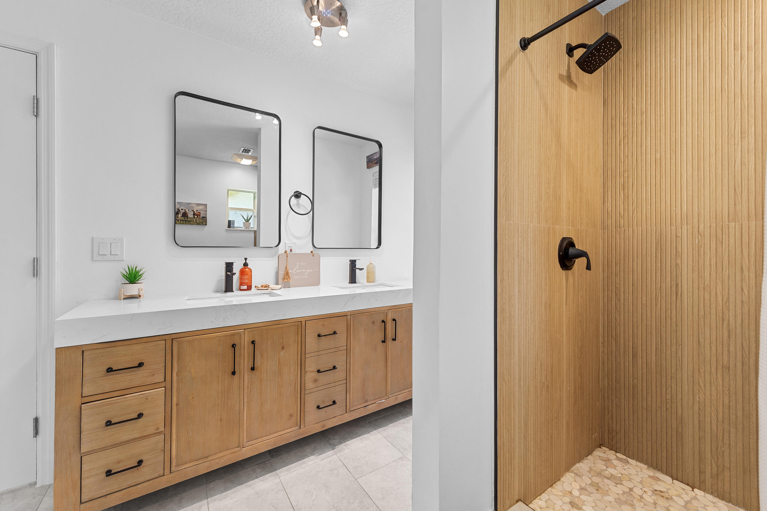 18389 41st Road North The Acreage, FL 33470 - Photo 33 of 44 a bathroom with a double vanity sink a mirror and shower