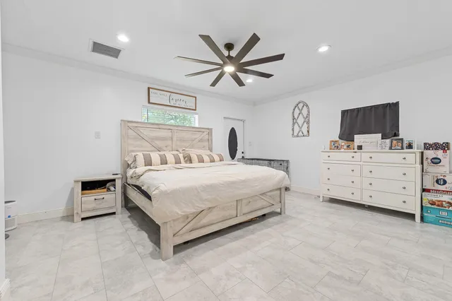 a bedroom with a bed and a flat tv screen on the dresser