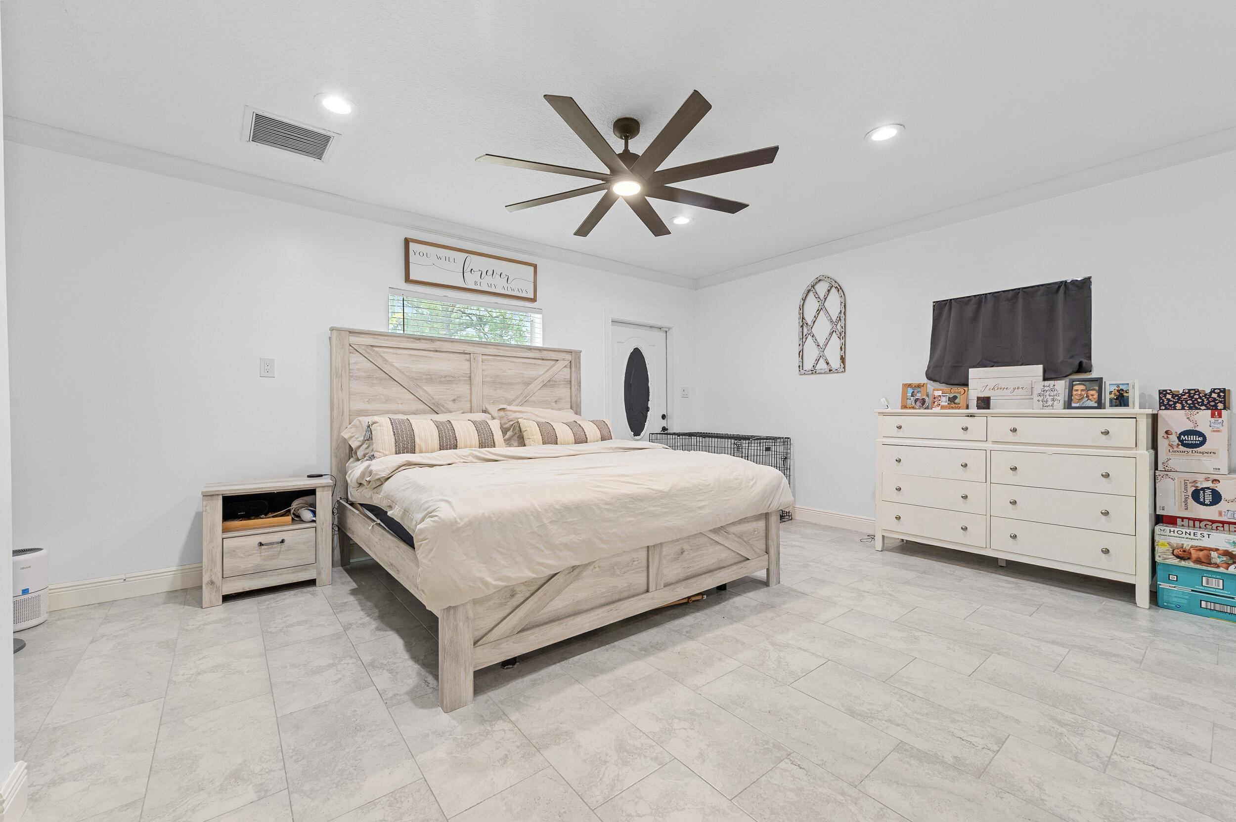 18389 41st Road North The Acreage, FL 33470 - Photo 34 of 44 a bedroom with a bed and a flat tv screen on the dresser