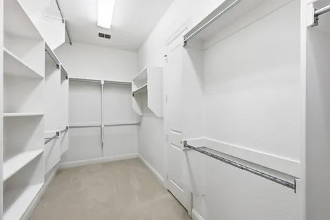 a view of walk in closet with empty racks