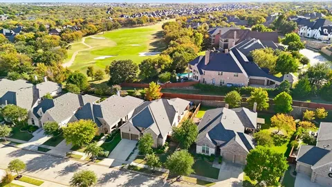 an aerial view of residential houses with outdoor space and swimming pool