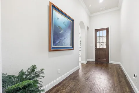 an empty room with wooden floor and a painting on the wall