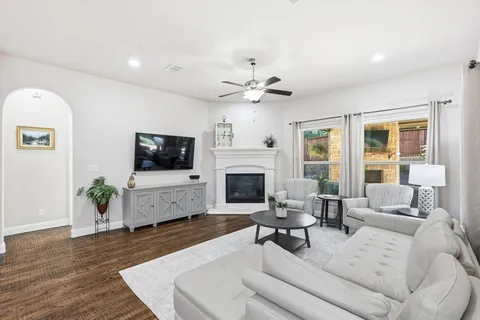 a living room with furniture a fireplace and a flat screen tv