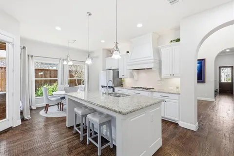 a kitchen with a table chairs stove and wooden floor
