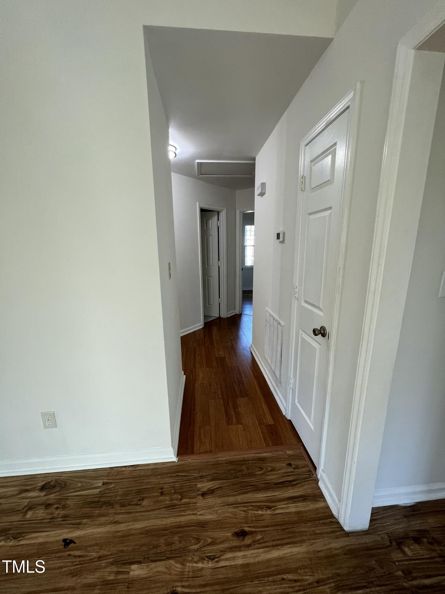 4416 Labrador Drive Raleigh, NC 27616 - Photo 6 of 19 a view of a hallway with wooden floor and a bathroom