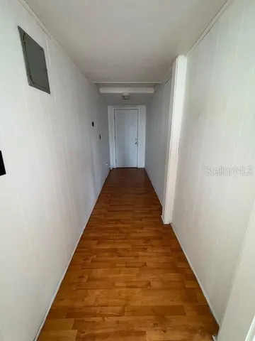 a view of a hallway with wooden floor